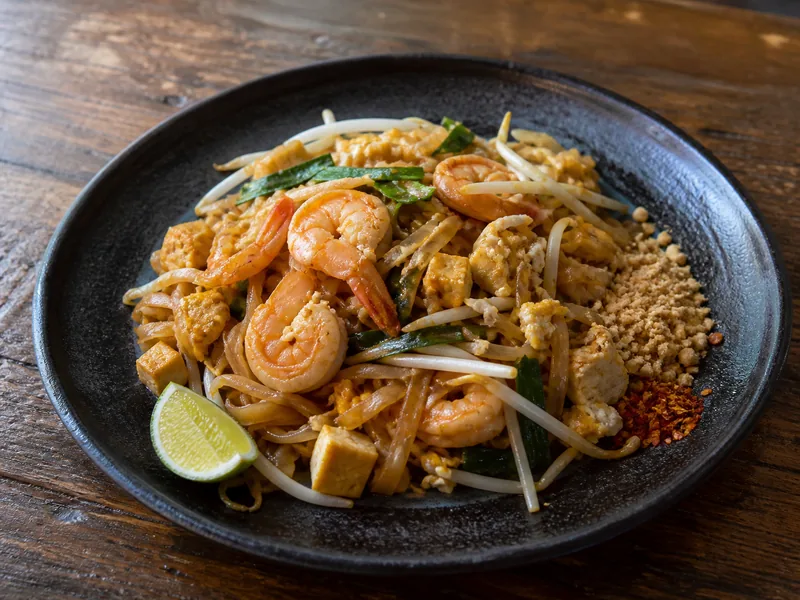 Pad Thai z makaronem ryżowym, krewetkami, ziołami i orzeszkami.